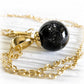 14k gold memorial necklace with a black glass marble on a white background