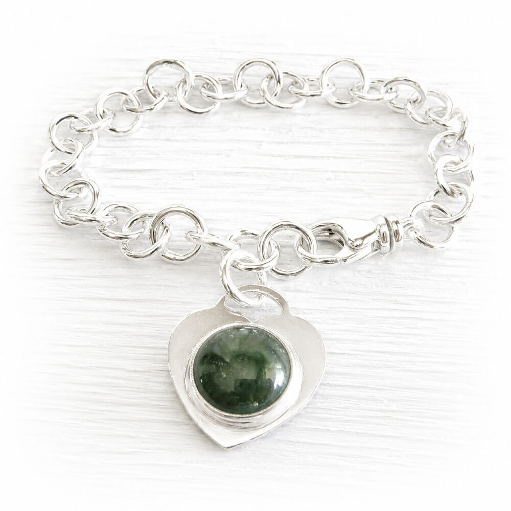 Sterling silver memorial charm bracelet with a heart-shaped charm featuring a green handcrafted memorial glass cabochon infused with ashes