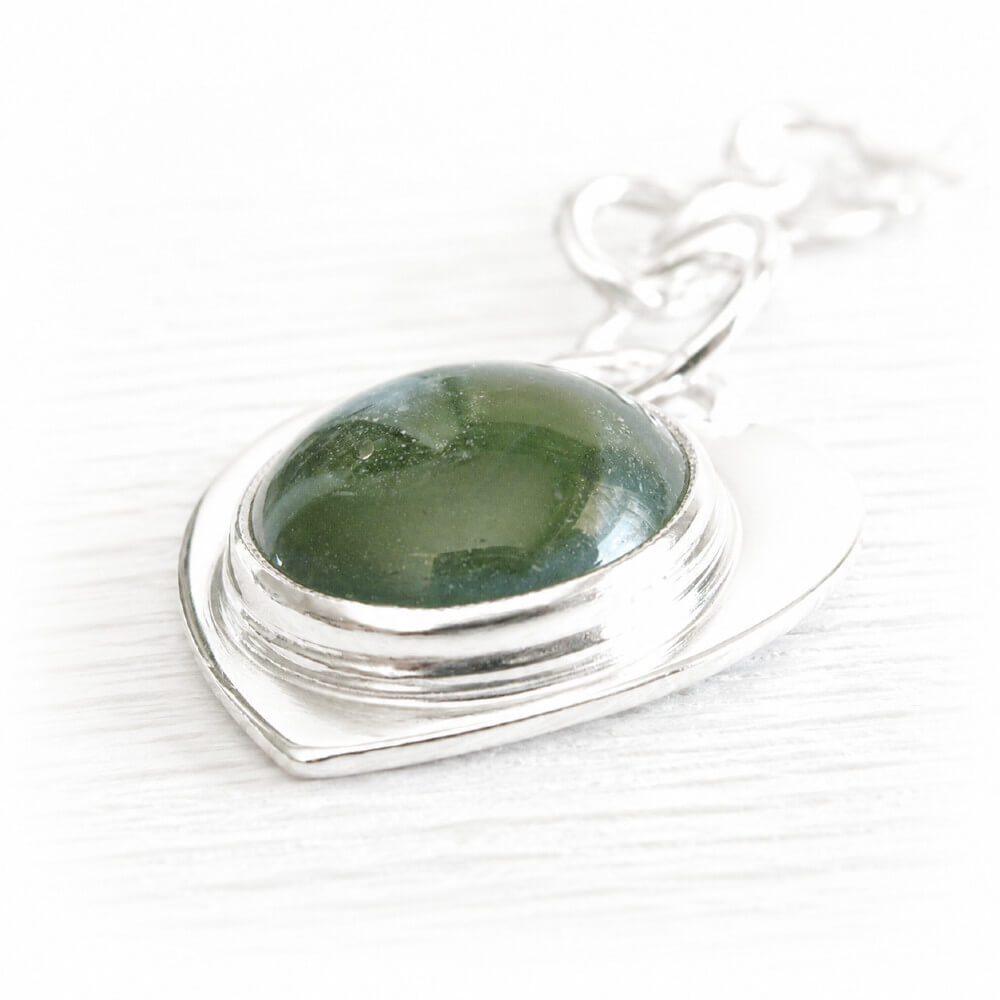 Green hand blown glass cremation cabochon set on sterling silver with cremation ashes sealed within the glass