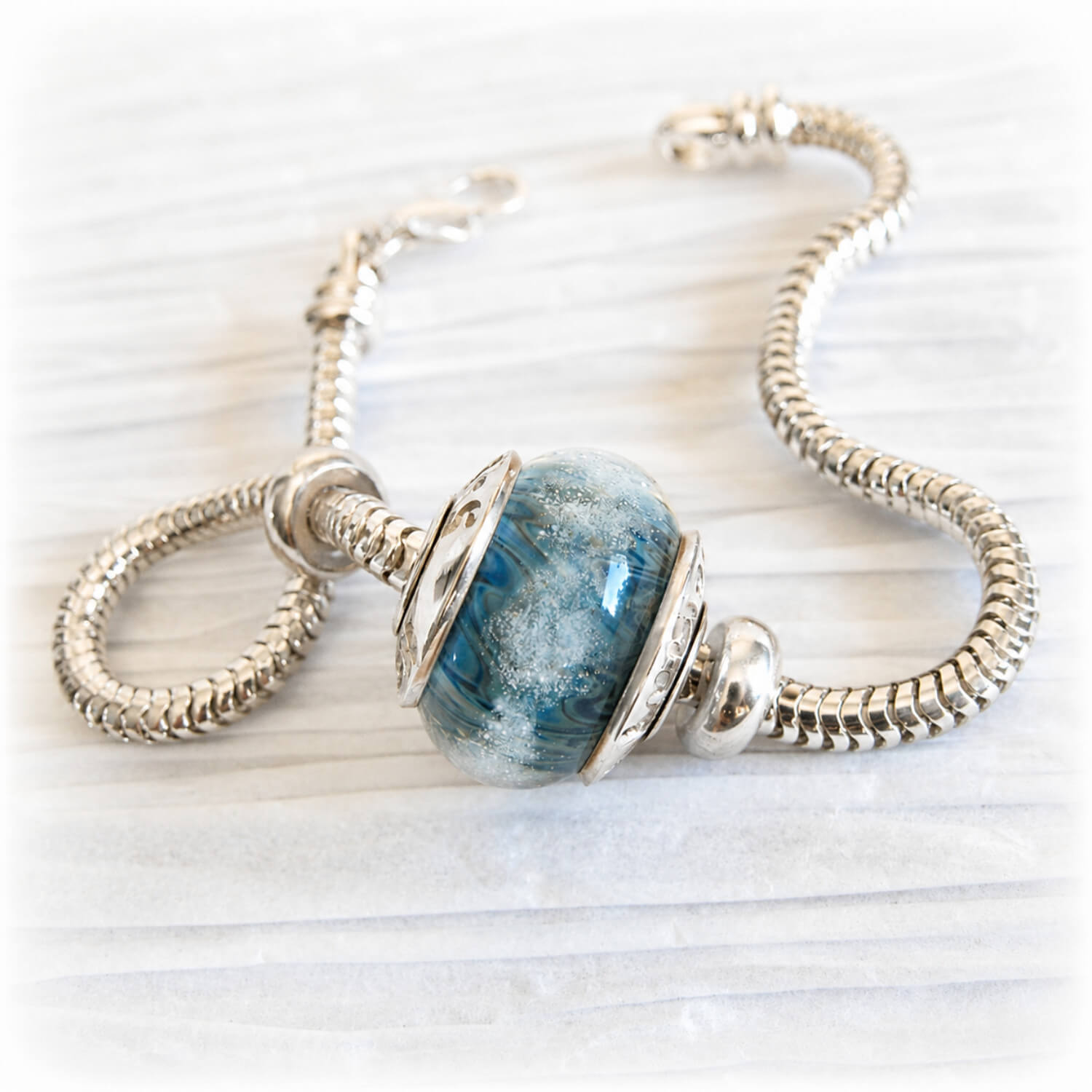 Snake chain charm bracelet with a blue memorial bead infused with a loved one ashes