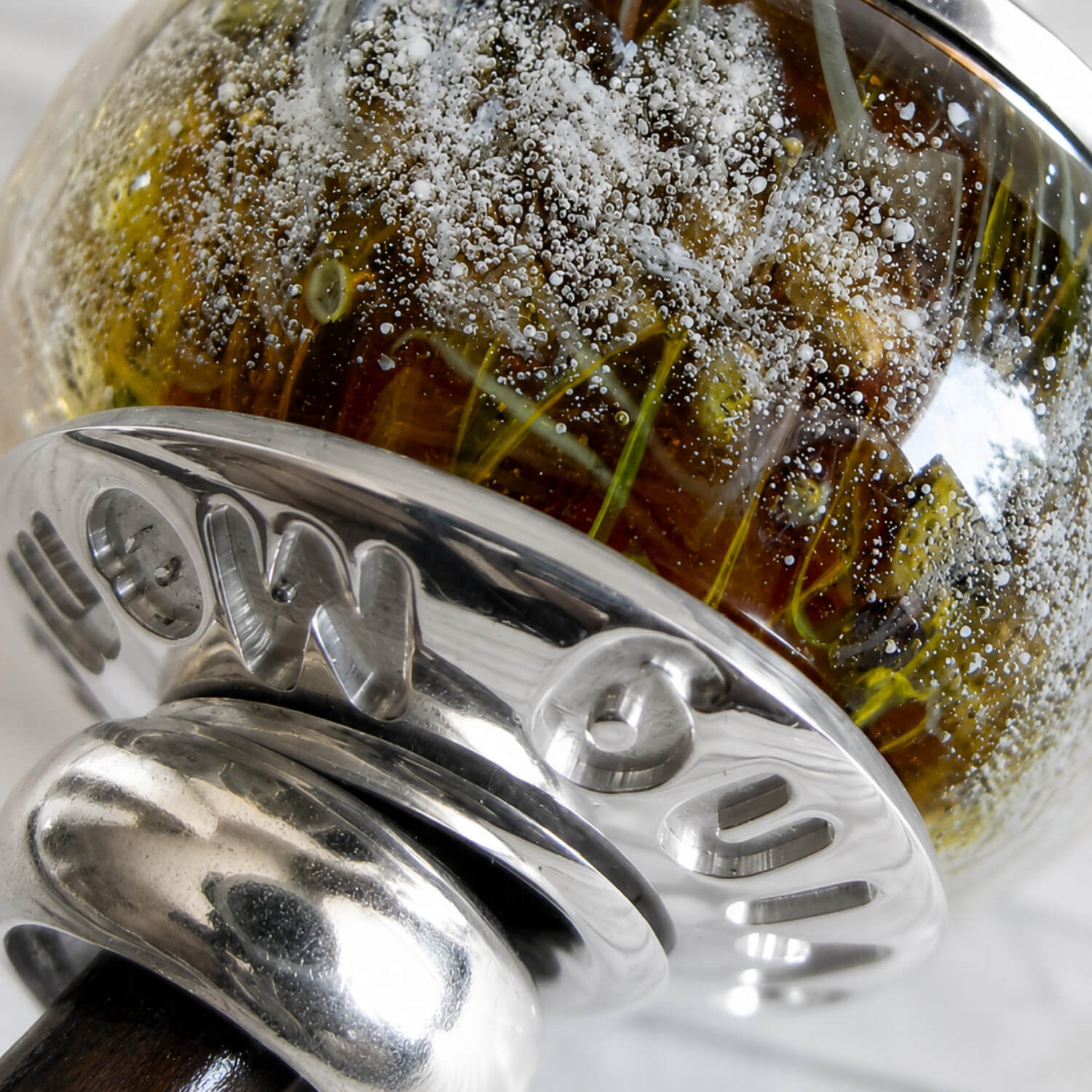 Close up of custom engraving on a hand blown glass cremation bead