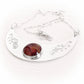 Artisan crafted memorial necklace with deep engraving and a dark red hand blown glass cremation stone