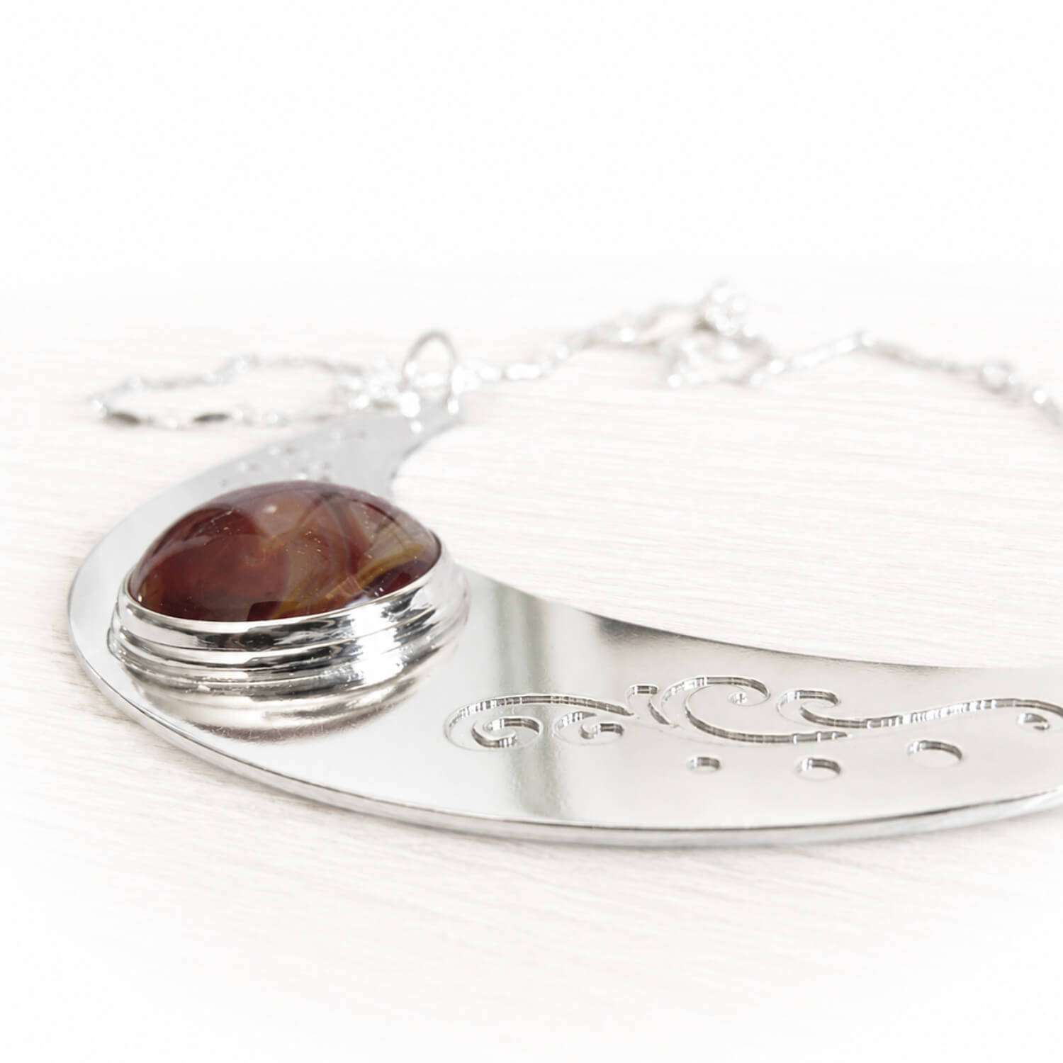 Crescent moon shaped sterling silver memorial pendant with engraving and an ash infused hand blown glass gem stone