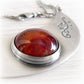 Ashes permanently sealed in hand blown glass in a sterling silver memorial pendant with engraving and an antique finish