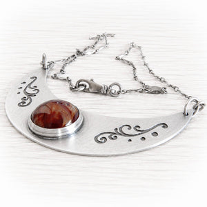 Sterling silver memorial necklace with an antique finish holding a glass cremation stone containing cremation ashes