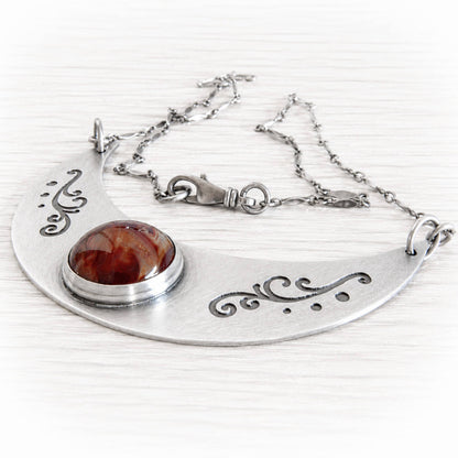 Sterling silver memorial necklace with an antique finish holding a glass cremation stone containing cremation ashes