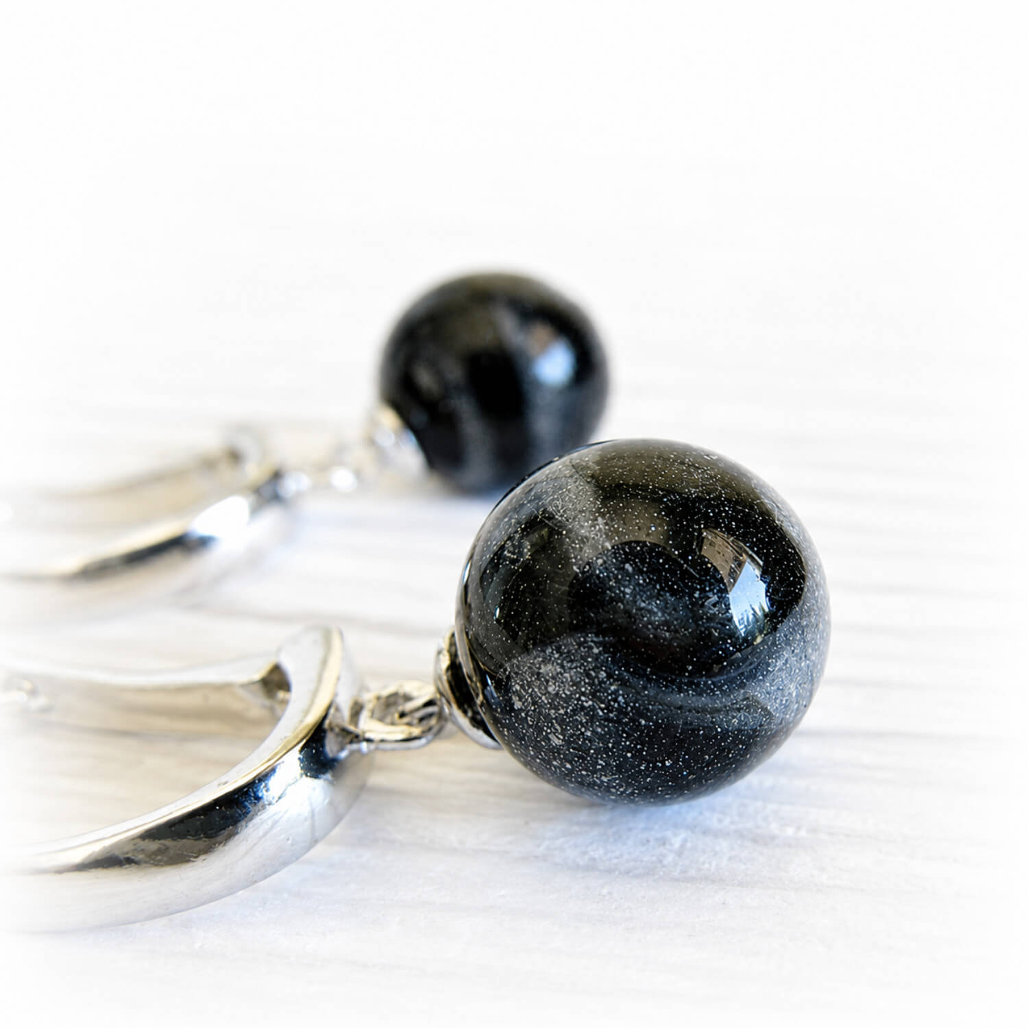 Cremation ashes sealed in black glass marbles set on sterling silver leaver back earrings
