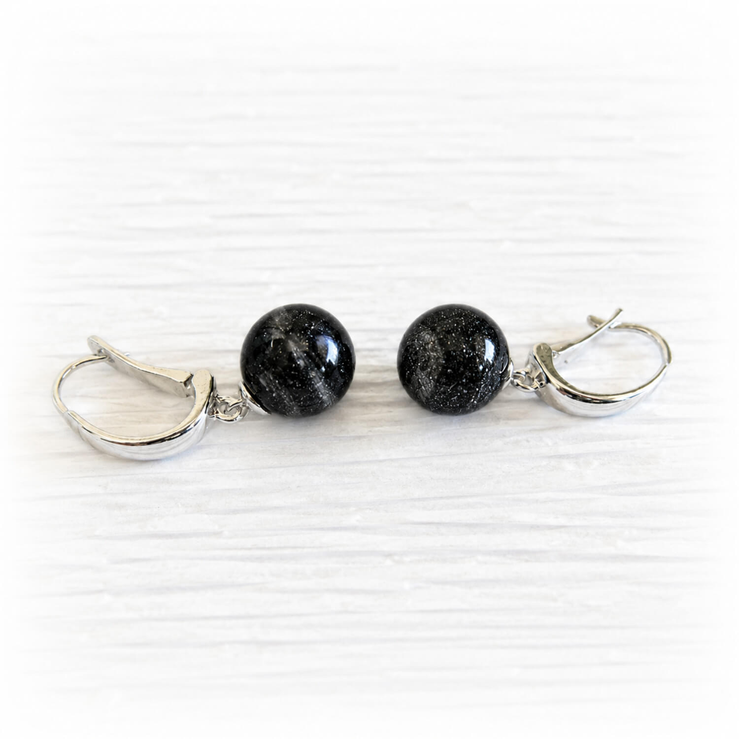 Pair of sterling silver memorial earrings with black glass marbles mixed with cremation ashes