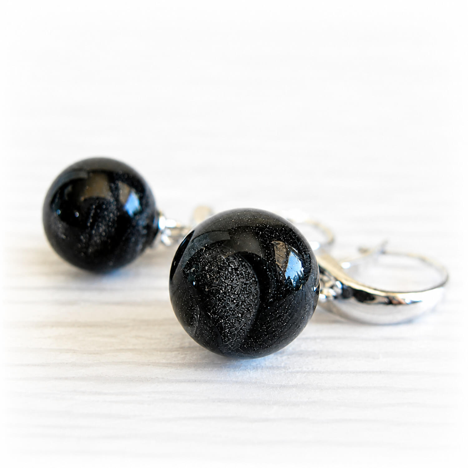 Pet memorial earrings with iridescent ash-infused glass marbles on a white background 