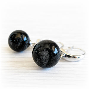 Pet memorial earrings with iridescent ash-infused glass marbles on a white background 
