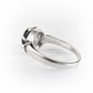 A silver ring with a cremation glass cabochon in a prong setting, shown on a light gray background.