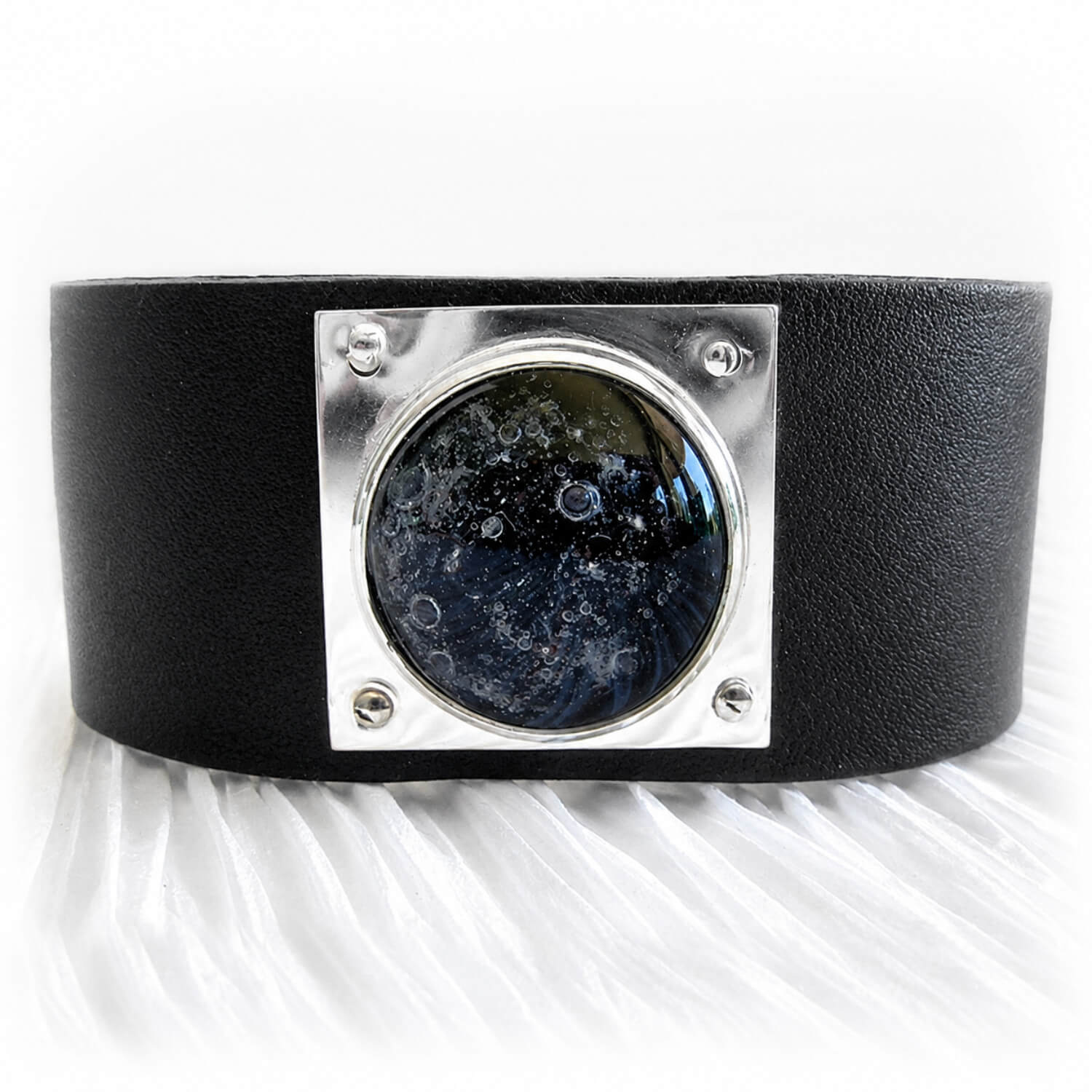 Black leather cuff bracelet with a black glass dome centered on a sterling silver square