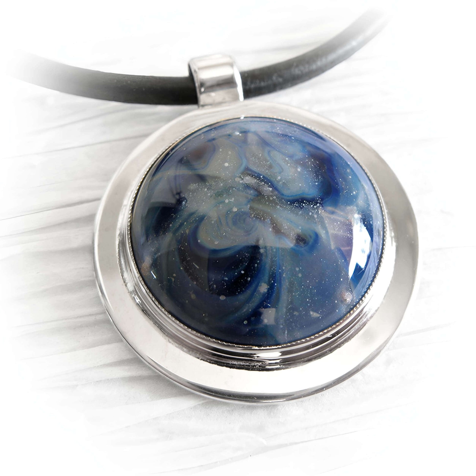 Close up of a blue artisan made cremation cabochon set in sterling silver 