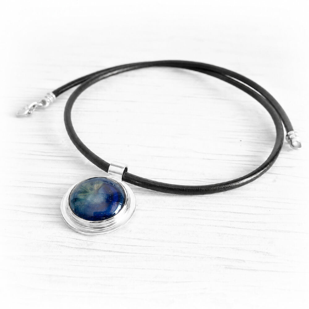 Sterling silver memorial necklace with blue ash-infused glass on a black leather chord necklace