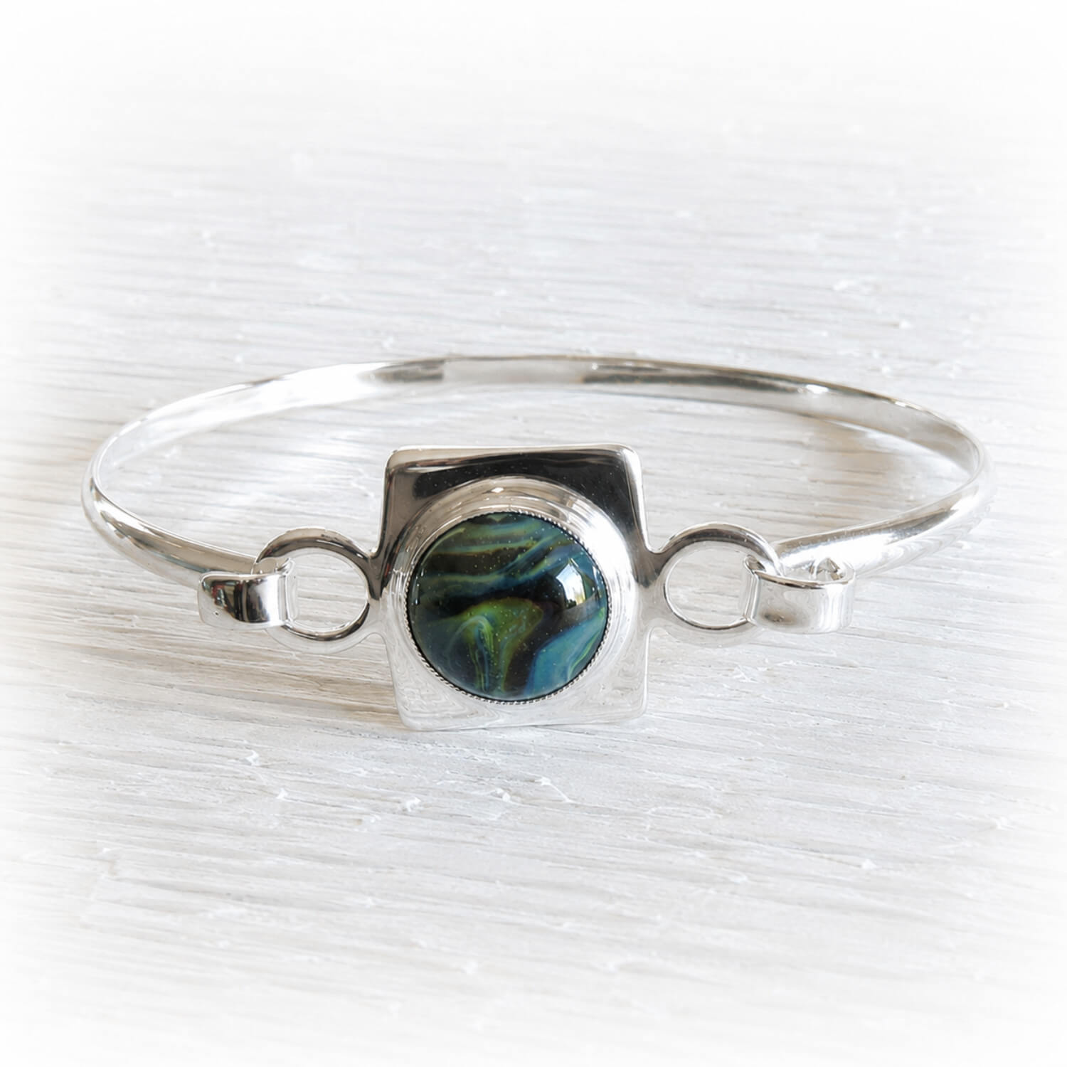 Sterling silver memorial bangle bracelet with a glass center piece infused with pet ashes