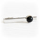 Black glass memorial gem hand blown with cremation ashes sealed within the glass set on a sterling silver tie bar