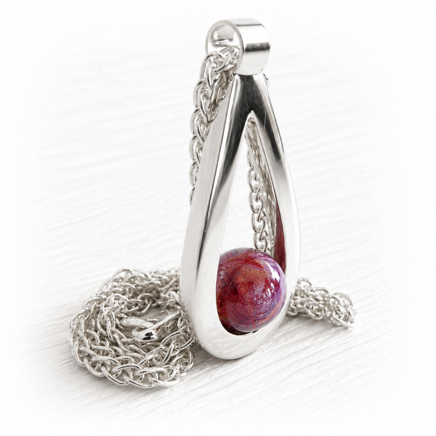Brightly colored cremation marble infused with ashes set in a hand made polished sterling silver teardrop pendant 