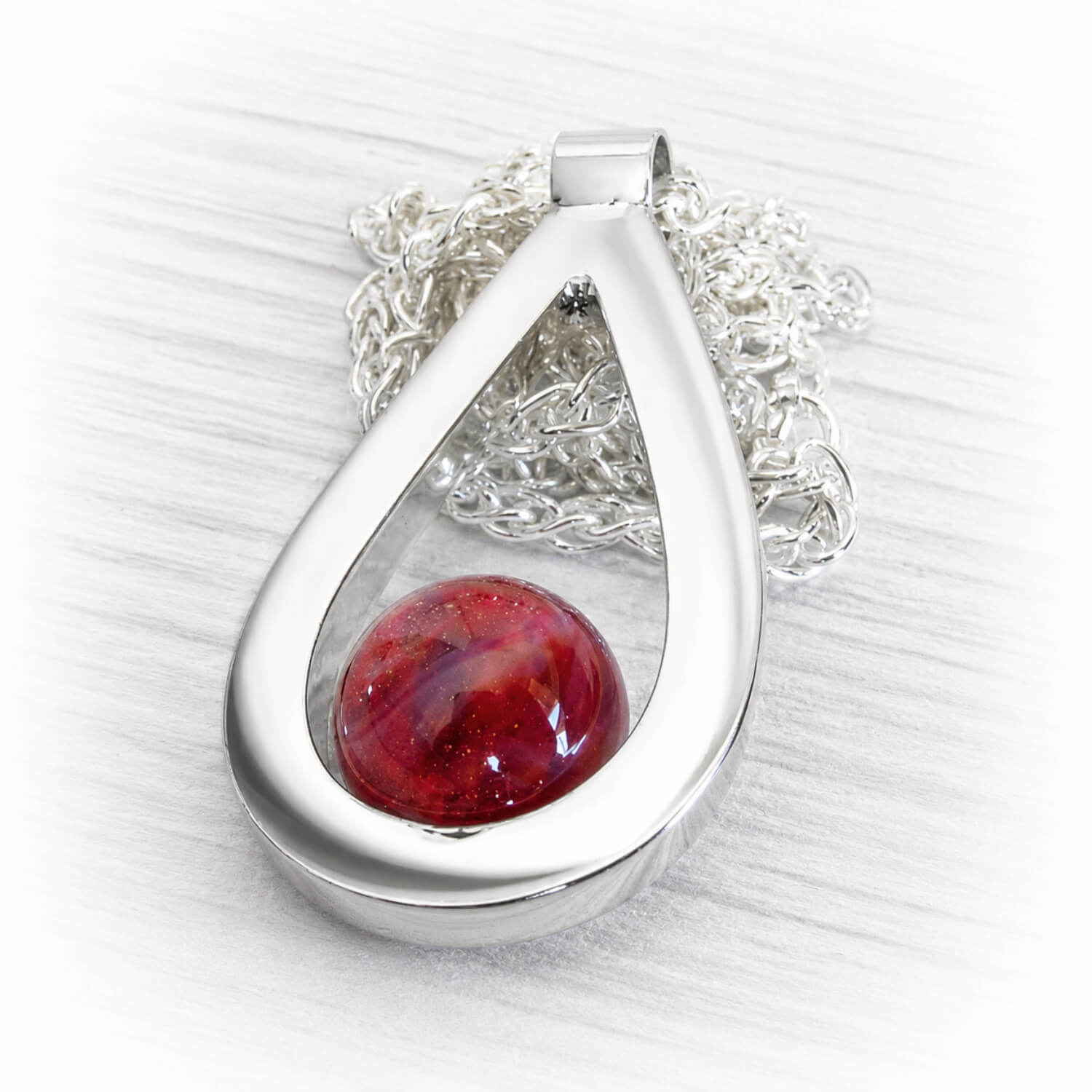 Artisan made sterling silver memorial necklace featuring a handcrafted glass marble infused with cremation ashes