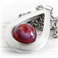 Hand forged sterling silver pendant showcasing a dark red hand blown glass marble infused with a pet ashes