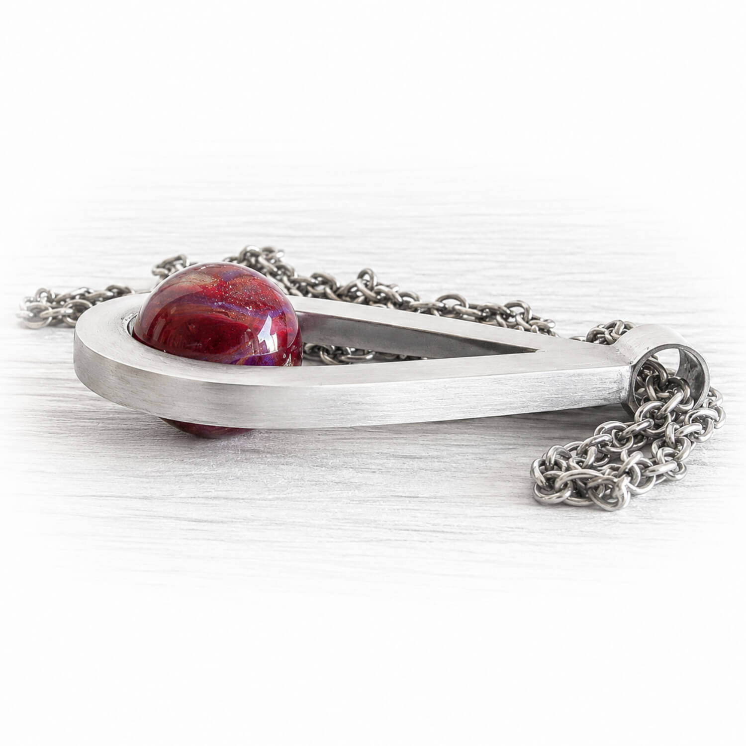 Artisan forged teardrop memorial pendant made from thick solid sterling silver adorned with a cremation glass marble