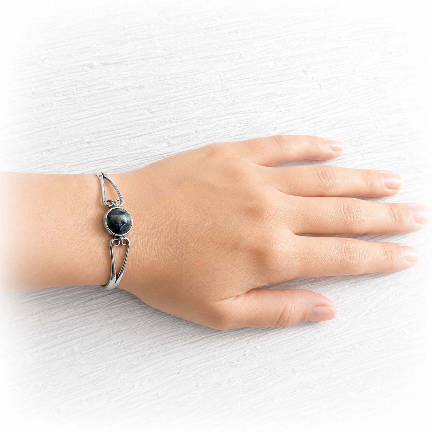 Memorial cuff bracelet featuring a hand crafted black glass cremation gem stone on the wrist of a model