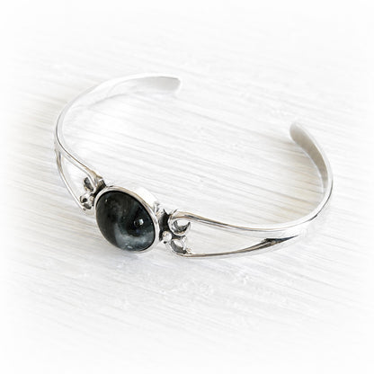 Polished sterling silver cuff bracelet with a centered hand blown glass cremation gem infused with pet ashes