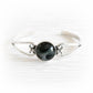 Cremation ashes sealed within black hand blown glass set in a sterling silver memorial cuff bracelet