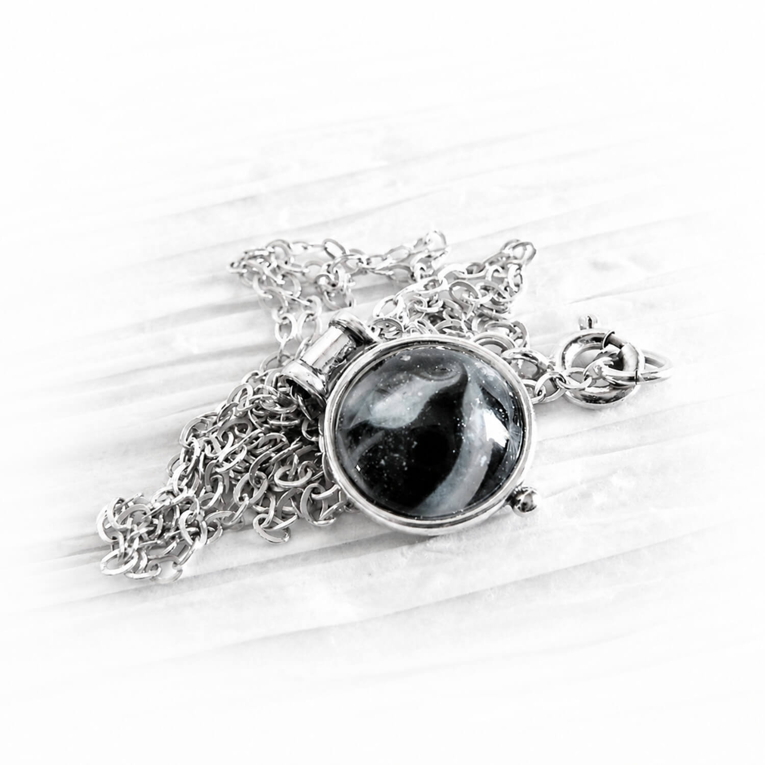 Dainty sterling silver memorial necklace with a black and white hand blown ash infused glass gem