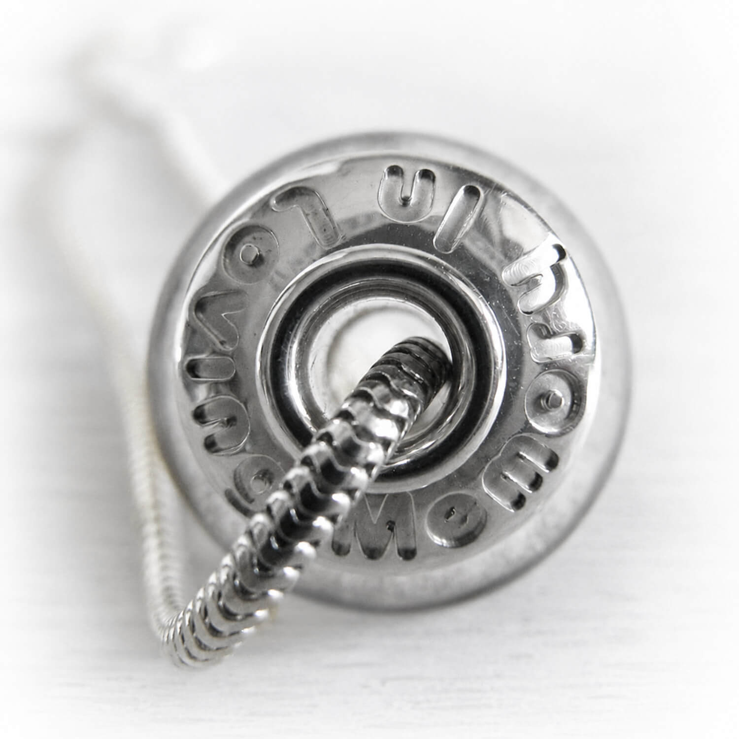 Close-up of a silver charm memorial bead with In Loving memory engraved
