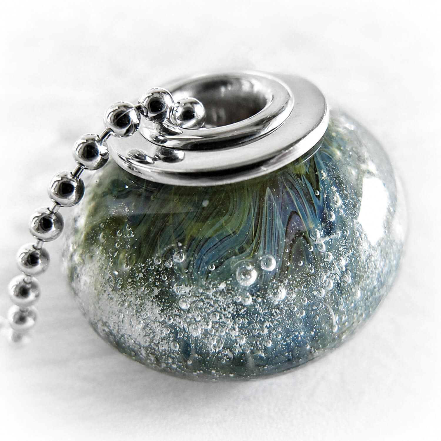 Handcrafted glass bead keepsake incorporating ashes set with sterling silver on a silver bead chain