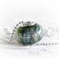 Cremation ashes infused into an artisan-crafted glass bead set with sterling silver on a silver necklace