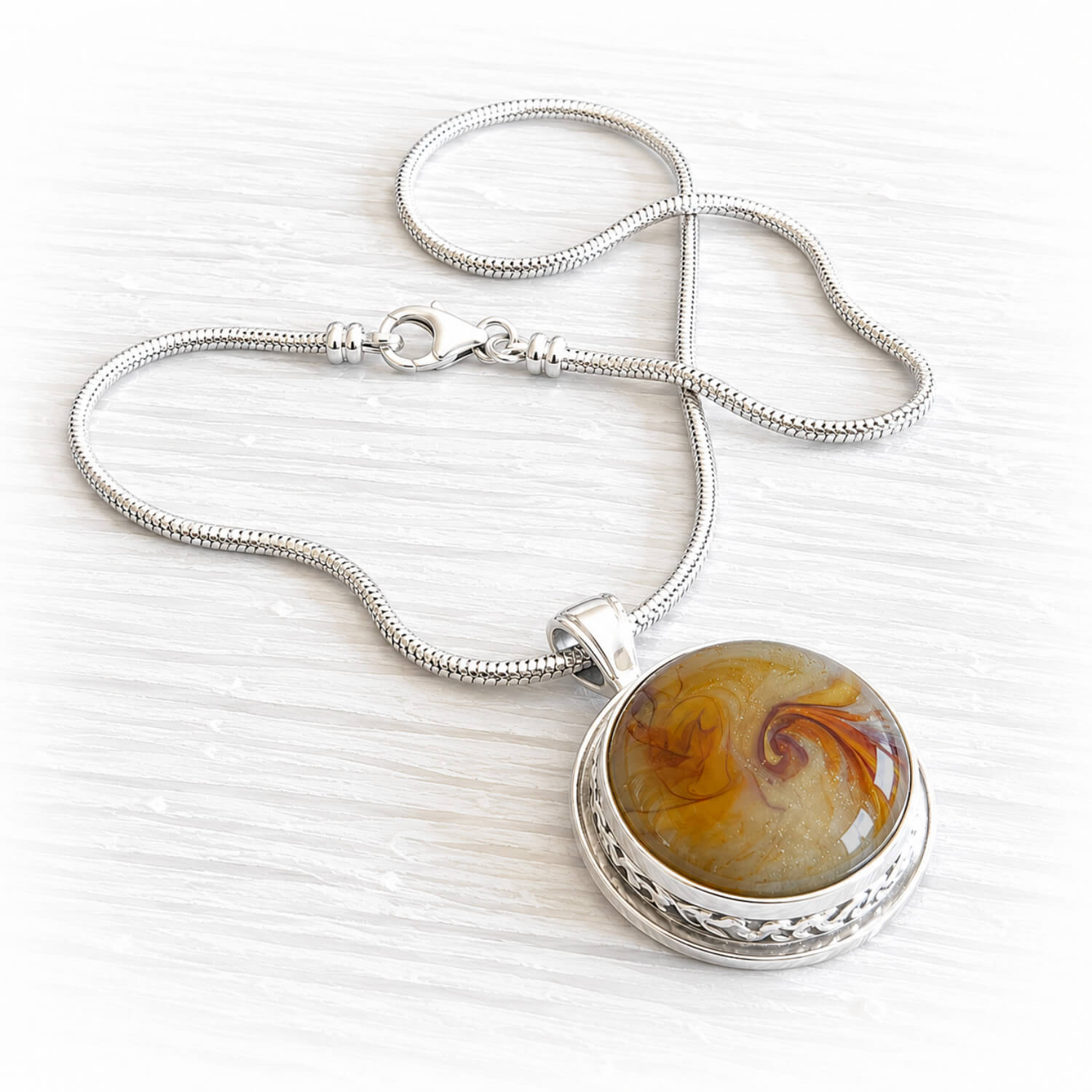 Remembrance necklace with yellow and amber memorial glass containing ashes in sterling silver