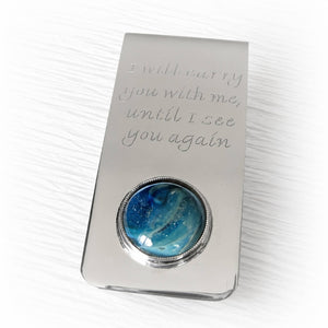 Handmade sterling silver money clip showcasing a hand blown glass cabochon with ashes suspended within the glass and customized engraving 