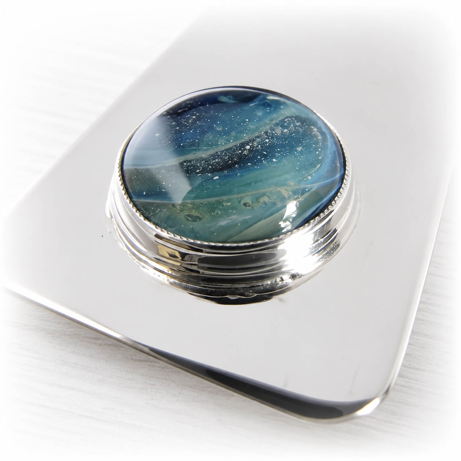 Blue and aqua artisan crafted glass cabochon containing cremation ashes set on a sterling silver money clip