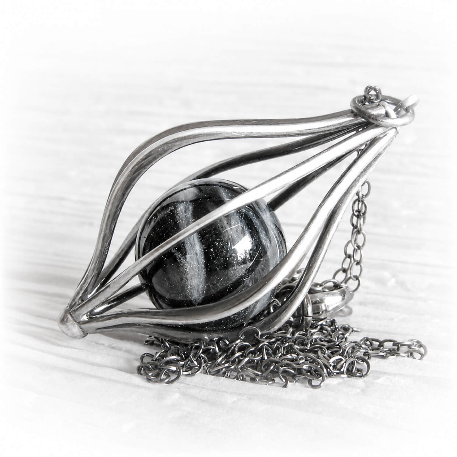 Hand blown glass pet memorial marble in a sterling silver pendant with an antique finish
