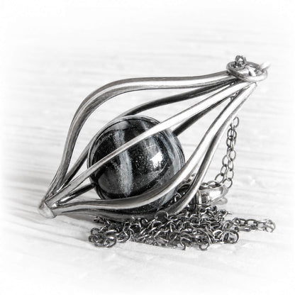 Hand blown glass pet memorial marble in a sterling silver pendant with an antique finish