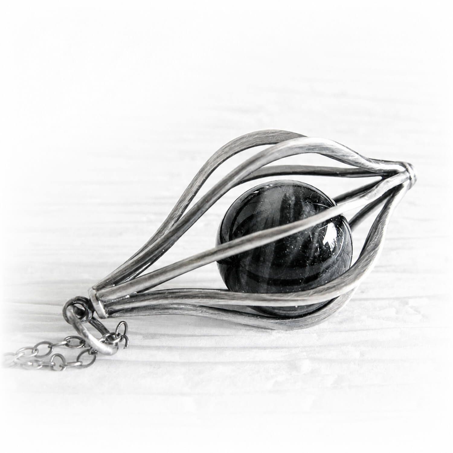 Sterling silver cage pendant with an antique finish featuring a black cremation marble