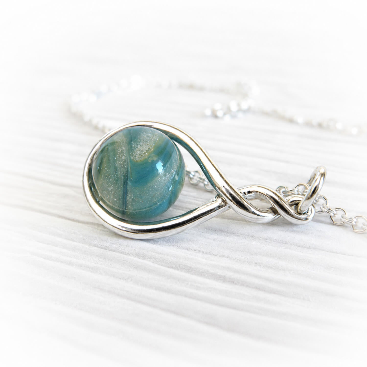 Sterling silver pendant with an aqua and turquoise hand blown glass memorial marblel
