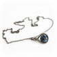 Sterling silver necklace with an antique finish featuring a blue artisan made glass marble containing cremation ashes
