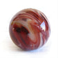 Swirls of red glass and pet ashes creating a large memorial marble