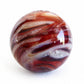 White cremation ashes swirled with red hand blown glass crafted into a large memorial marble