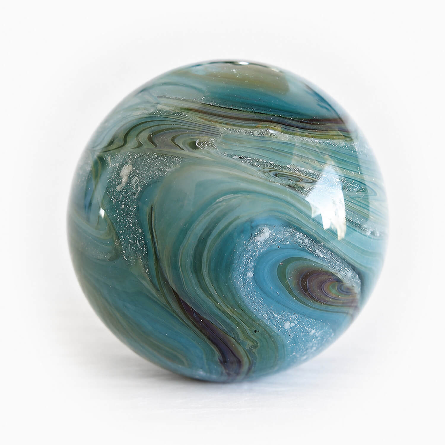 Swirls of aqua and blue glass mixed with cremation ashes into a large memorial marble