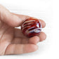 Hand holding a red memorial marble hand crafted from red hand blown glass infused with cremation ashes