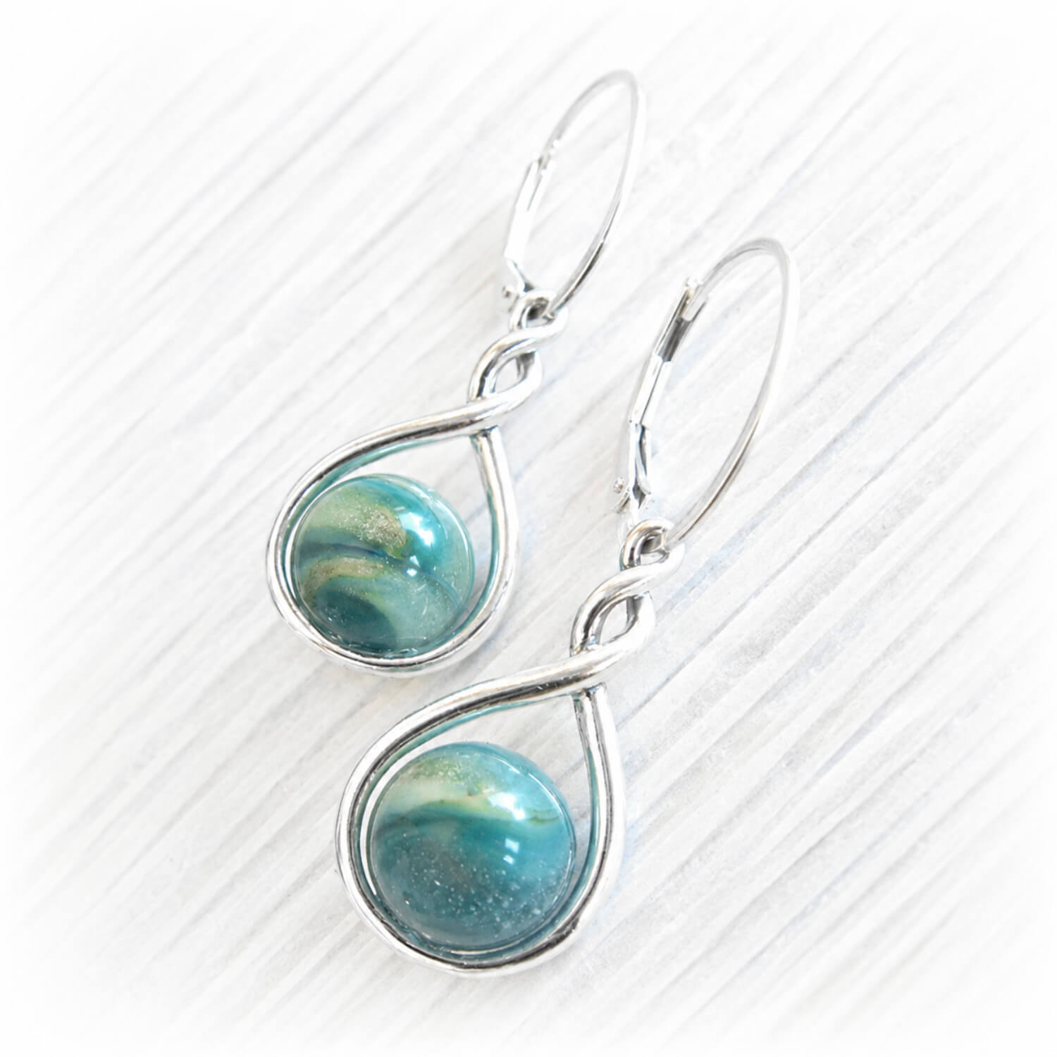 Pair of memorial earrings with hand blown glass marbles with ashes permanently encased in glass