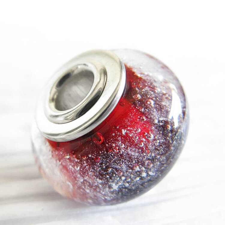 Cremation Ash Glass red bead charm with sterling silver metal accent on a white background