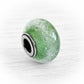 Green artisan made glass cremation charm bead with encased ashes floating over green glass fit onto antique finished sterling silver 