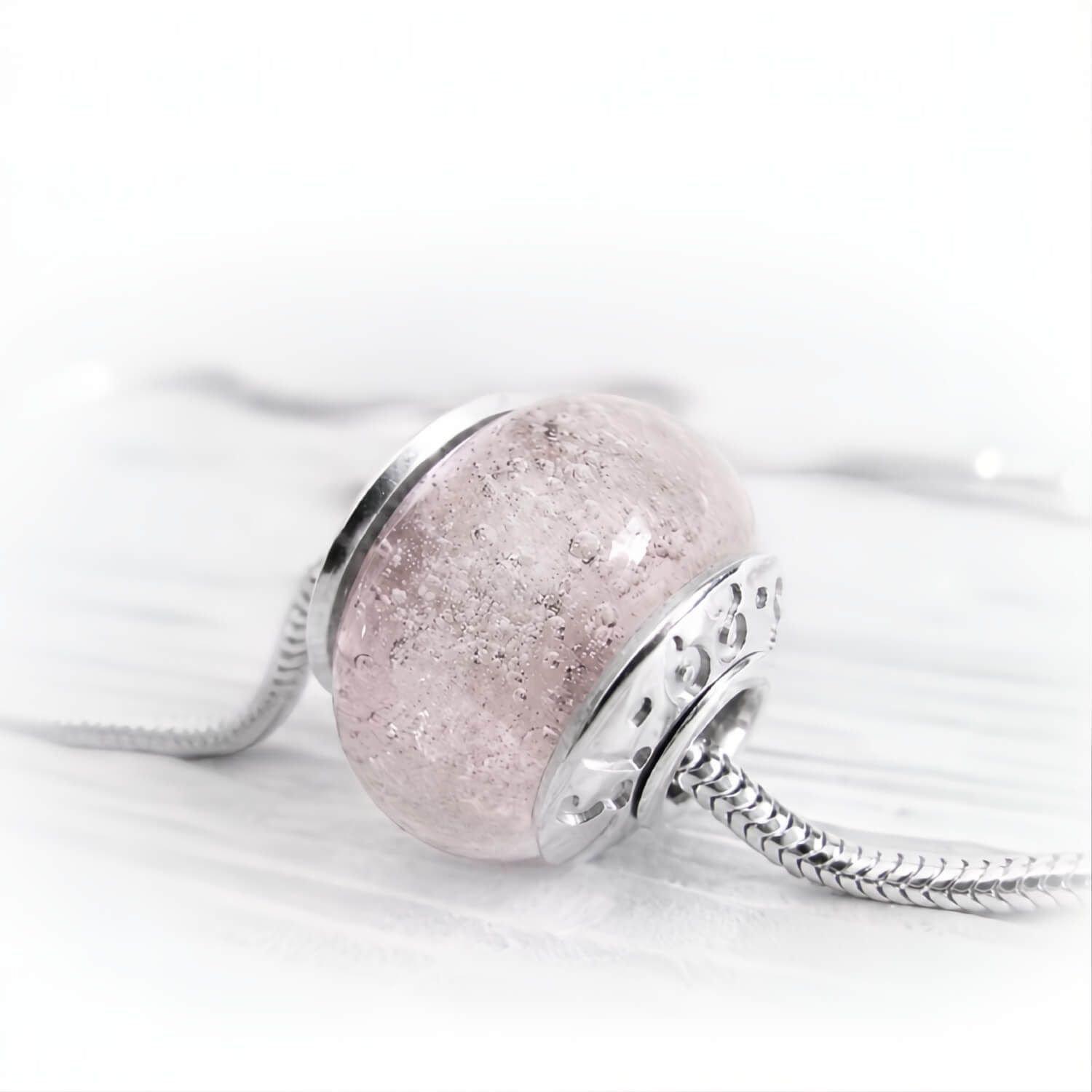 Light pink cremation bead set in sterling silver bead caps with  personalized inscription