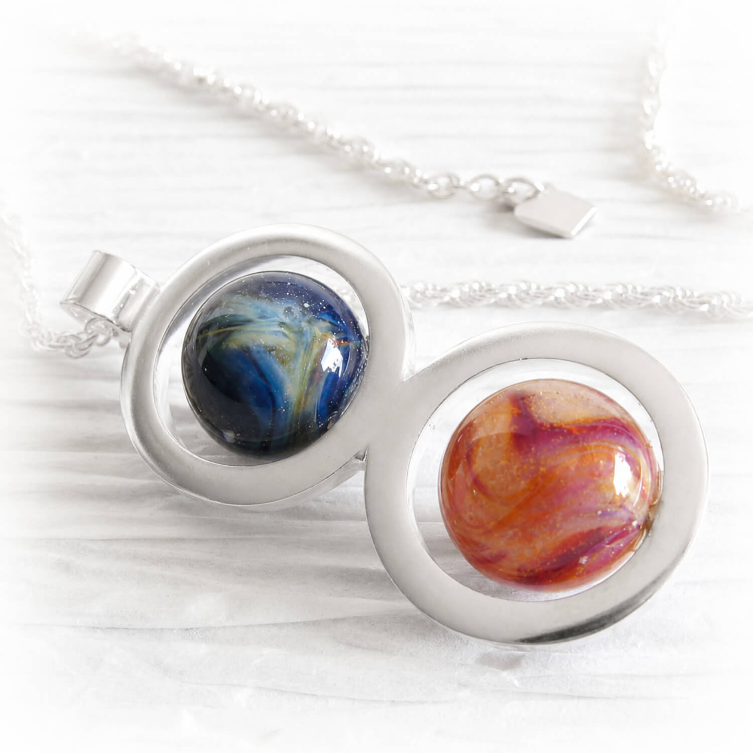 Handmade memorial necklace with two colorful glass marbles swirled with cremation ashes 