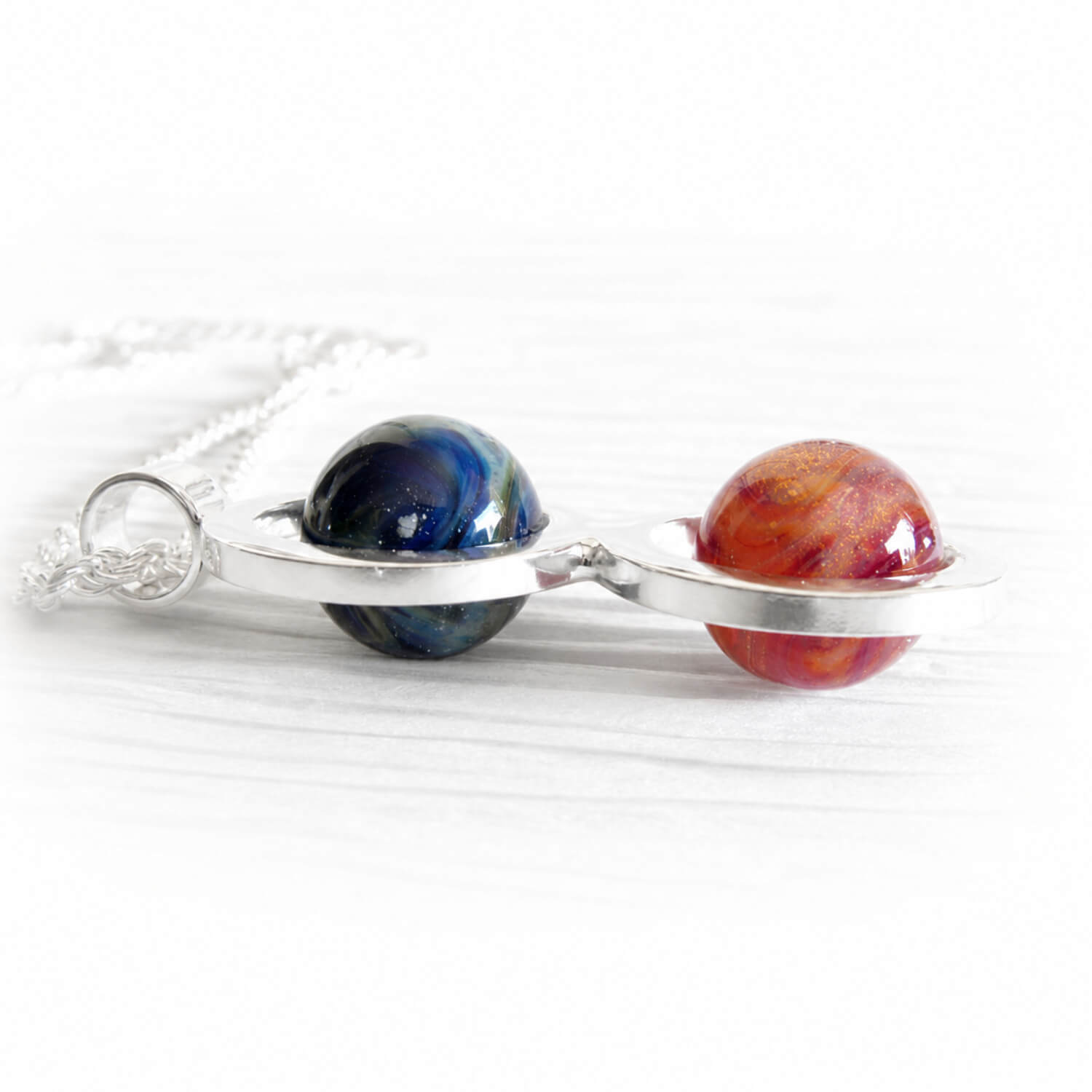 Two artisan made glass marbles handcrafted with cremation ashes set in a sterling silver memorial necklace