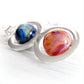 Colorful hand crafted glass marbles with swirls of cremation ashes mounted in a sterling silver pendant